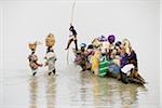 People crossing the Bani river, after a market day in Djenee, a UNESCO World Heritage Site. Mali, West Africa