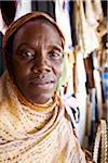 Kigali, Rwanda. An old woman trades traditional clothes in Kimironko market.