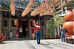 Singapour, Singapour, Raffles Place. Fidèles sous la spirale d'encens bobines au Temple Wak Hai Cheng Bio.