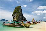 Thailand, Krabi, Railay.  Longtail boats at Hat Phra Nang (Phra Nang Beach) with Happy Island in the background.