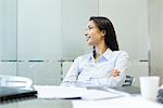 Businesswoman with arms folded, looking away in thought