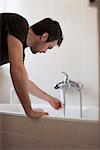 Man testing water temperature