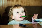 Toddler girl feeding herself with spoon
