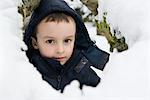 Boy sitting in snow, portrait