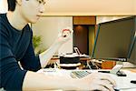 Office worker using computer, squeezing stress ball with one hand