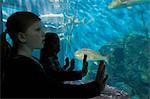 Girls staring at fish in aquarium