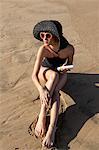 Woman on beach applying suncream
