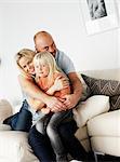 A smiling family sitting in a couch, Sweden.