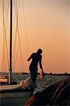 Woman on a sailing-boat at sunset, Sweden.