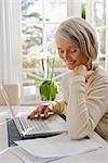 Senior woman using a laptop at home, Sweden.