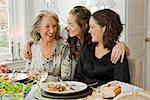 Portrait of a grandmother, daughter and granddaughter at a dinner table, Sweden.