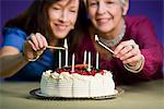 Deux femmes avec un gâteau d'anniversaire.