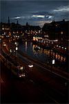 Tramway dans la ville le long du canal pendant la nuit