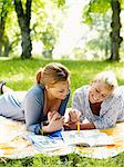 Women lying on blanket and learning