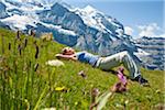 Woman Lying on Grass on Mountain Side, Bernese Oberland, Switzerland