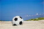 Soccer ball on sandy beach after game