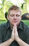 Man prays with his hands pressed together