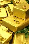 Presents wrapped in gold paper with ribbon (suitable for christmas, birthdays, anniversaries, valentine's day etc).