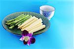 Asparagus and corn on a plate with a pink orchid