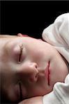 cute sleeping young boy shot over black