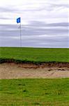 golf course; sand ditch, blue flag on post