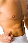 Closeup of athletic male body - there is no fat. Isolated on white in studio.