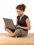 isolated on white female teenager sitting on the carpet with laptop