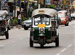 Tuk-tuk (cab) speeding on the street. Picture taken in Bangkok / Thailand