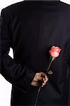 A man with business suite holding roses proposing.