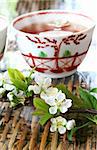Tea and blossom on rattan table