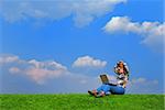 Girl with notebook sitting on grass against sky