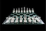 Glass Chess Pieces on a Frosted Glass Chess Board fully isolated on black