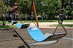 Close up of blue swing at the playground on a sunny day