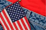 A small American flag against a pair of blue jeans and a t-shirt
