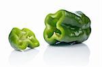 A fresh and tasty green pepper slices reflected on white background. Shallow DOF