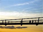 Silhouette of walking people and pedestrian bridge