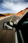 car driving through the Bighorn Canyon, Wyoming, with motion blur. SUV, focus on mirror.