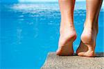 Woman about to dive into bright blue pool