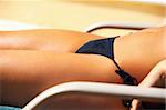 Sexy womans body part in bikini during sunbath laying on deckchair