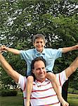 Boy Having Fun Playing on Mans Shoulders