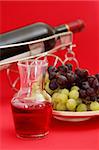 Wine and grapes on red background