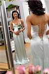 Portrait of an African-American woman in a elegant evening gown looking in mirror.