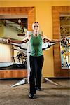 Prime adult Caucasian female using exercise equipment at gym.