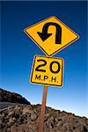 Warning road sign indicating curve and speed limit in Haleakala National Park, Maui, Hawaii.