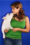 Caucasian prime adult female holding white terrier dog.