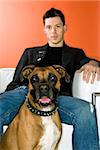 Young adult Caucasian male with Boxer dog.