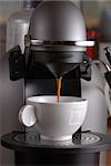 Coffee machine pouring espresso in cup