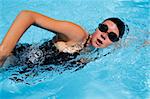 Female swimmer in blue pool with cap and goggles