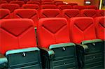 rows of red seats in a hall for a conference