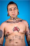 Barechested  Caucasian mid-adult man with tattoos and piercings.